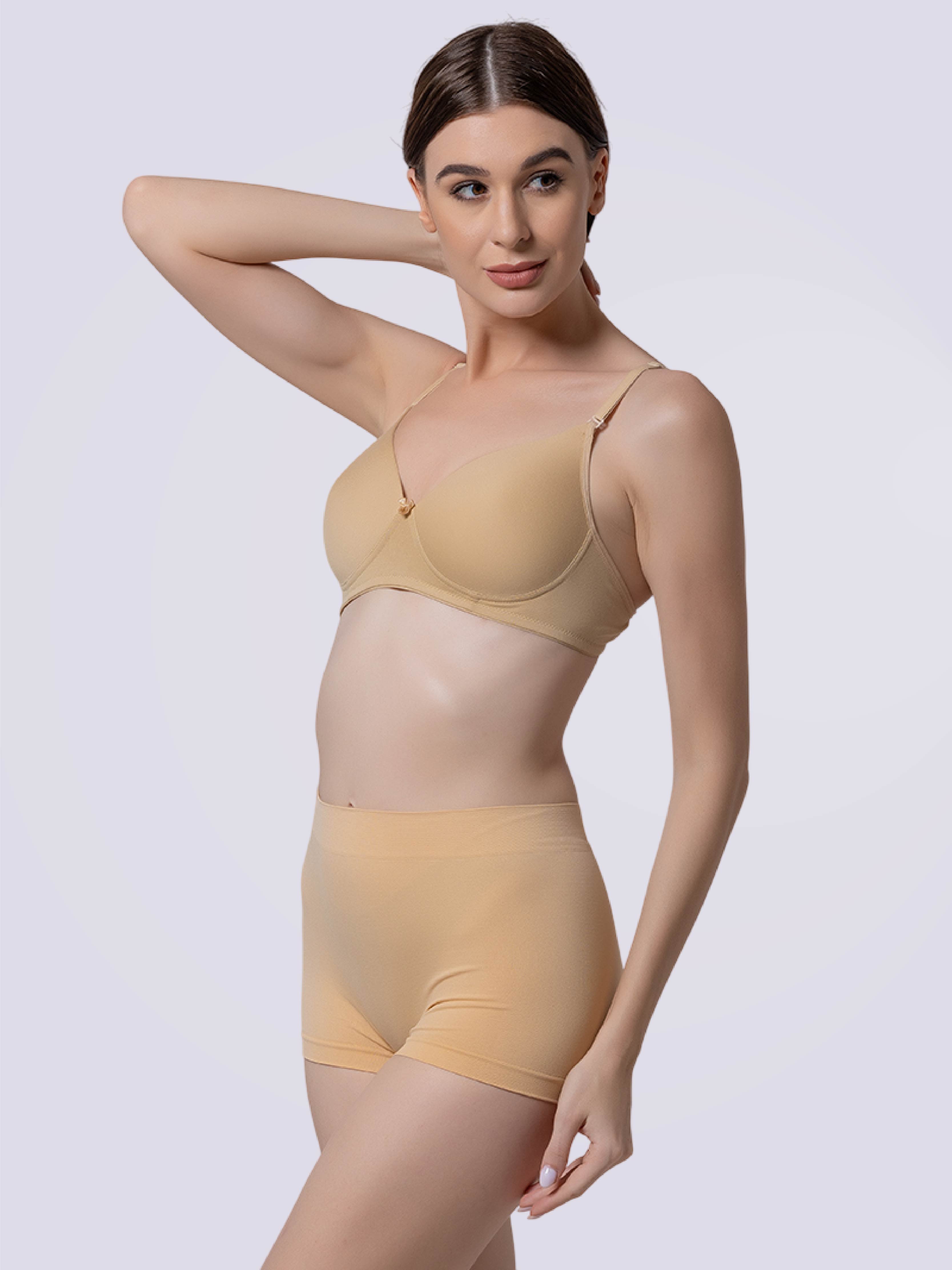 Woman wearing a beige bra and panties set on a white background